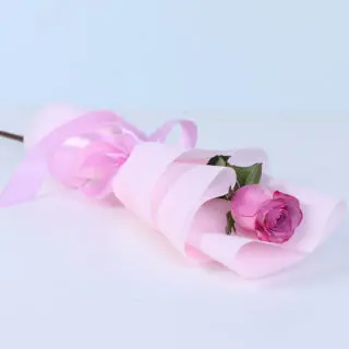 Fresh single purple rose bouquet with rich petals, elegantly wrapped in decorative paper and ribbon, ready for romantic or special occasion gifting