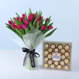 30 vibrant tulips are beautifully arranged in a bouquet, wrapped in decorative white paper and tied with a black satin ribbon.