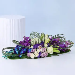 Rich purple and white floral styling with fresh flowers and green fillers creating a refined decorative setup.