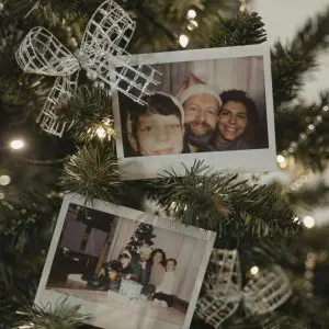 two Polaroid photos. The first Polaroid appears to show three individuals, possibly a family, with one wearing a Santa hat