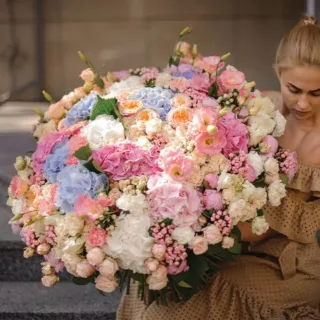 BTF Home 55 A woman holding a fantasy themed bouquet in baby blue, pink and white colors.