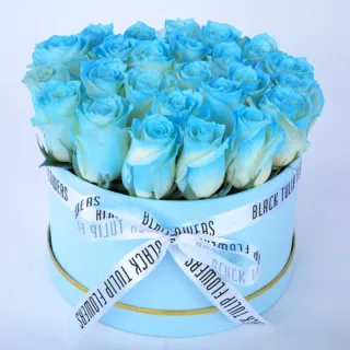 25-30 captivating blue roses in a blue box, elegantly tied with a white ribbon.