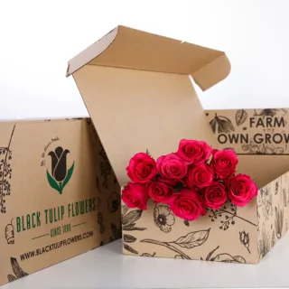 A bunch of dark pink roses in a sustainable brown box with flower food.