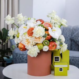 Peaceful Fruit Arrangement composed of mix fruits and flowers in a box with Patchi by Black Tulip Flowers.