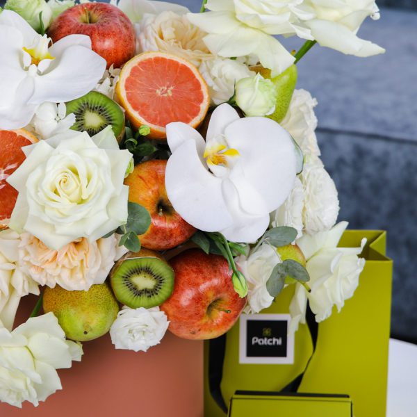 Peaceful Fruit Arrangement composed of mix fruits and flowers in a box with Patchi by Black Tulip Flowers.