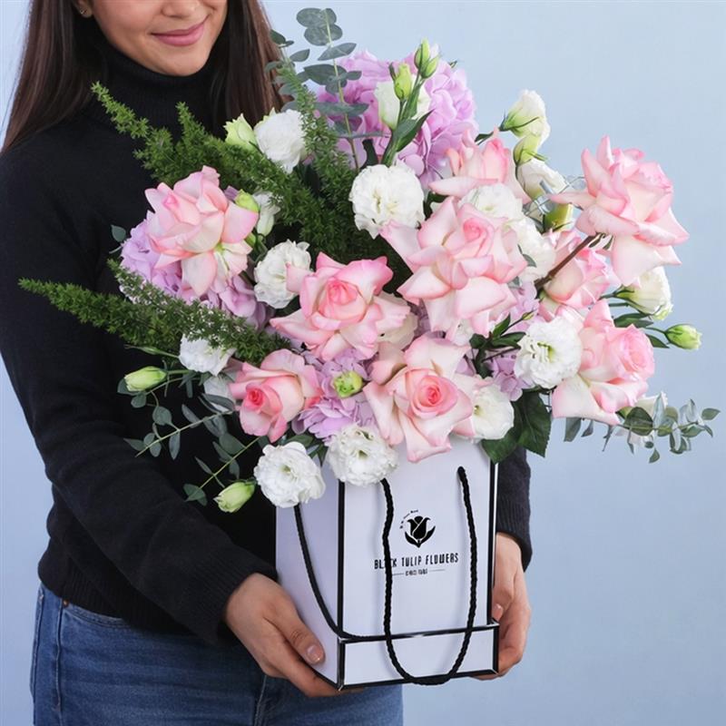 pink-delight-floral-display_2026_01 A beautiful floral arrangement featuring 10 roses, 5 hydrangeas, and a bunch of lisianthus, complemented by green leaves.