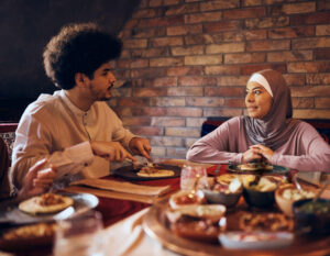 Couple eating on dining table with some Main Course, Dessert, Treats