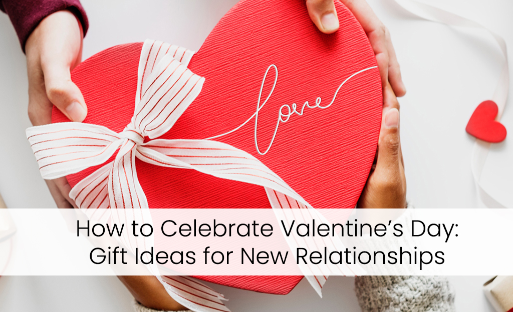 Two hands, one light and one dark, holding a heart-shaped gift box with a red ribbon and the word "Love" written on it. The text "How to Celebrate Valentine's Day: Gift Ideas for New Relationships" is displayed below the image.