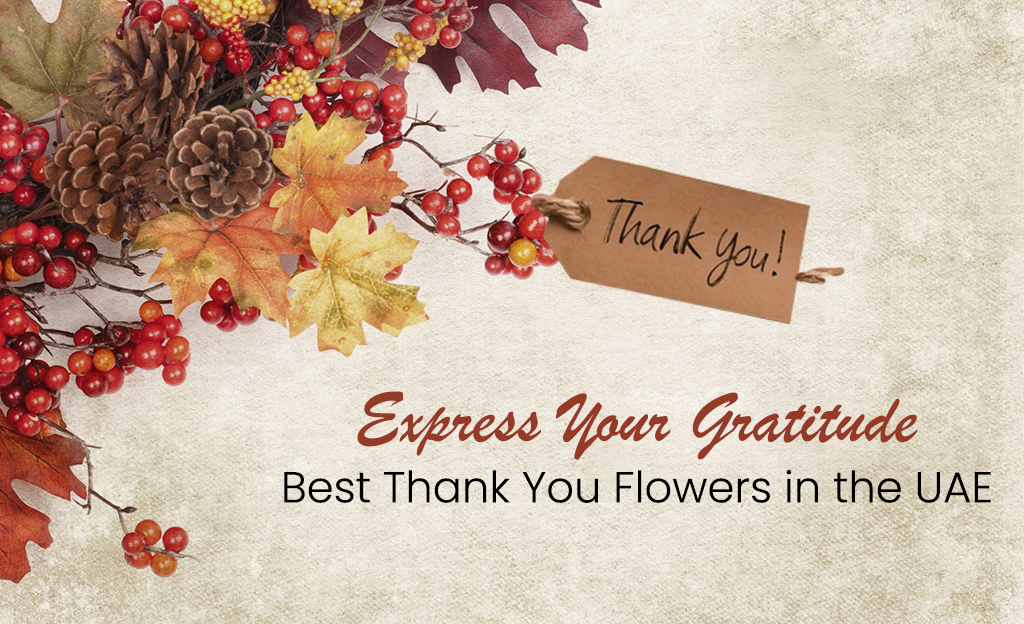 A festive autumnal arrangement with red berries, pinecones, and colorful leaves. A small, brown tag with the words "Thank You!" is attached to the arrangement. The text "Express Your Gratitude" and "Best Thank You Flowers in the UAE" is displayed below.