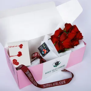 A bunch of dark red roses is neatly arranged inside the box.