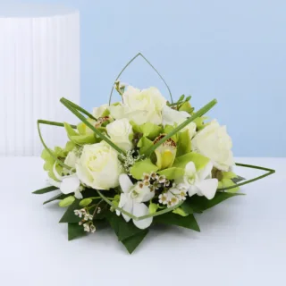 Refined floral arrangement featuring white orchids and roses styled for weddings, banquets, and premium décor