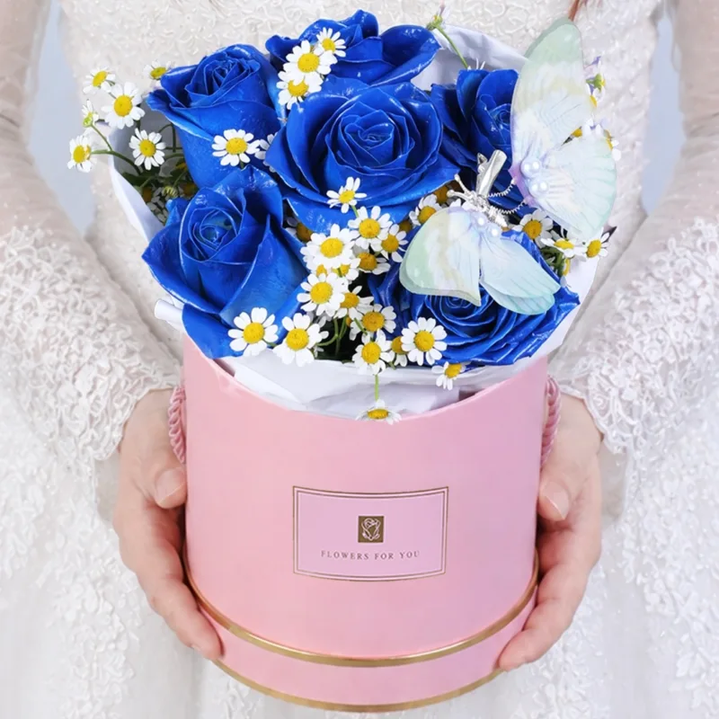 blue-butterfly-dream-box_2026_01 Blue rose box combined with tanacetum blooms and a butterfly accent arranged in a creative and eye-catching floral design.