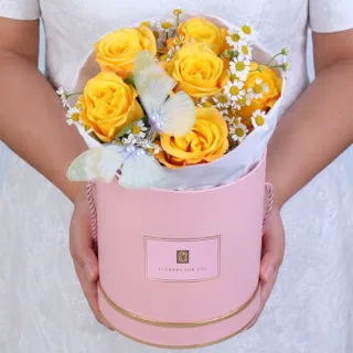Handcrafted floral box featuring yellow roses, delicate filler flowers, and a butterfly accent arranged in a fresh and uplifting design.