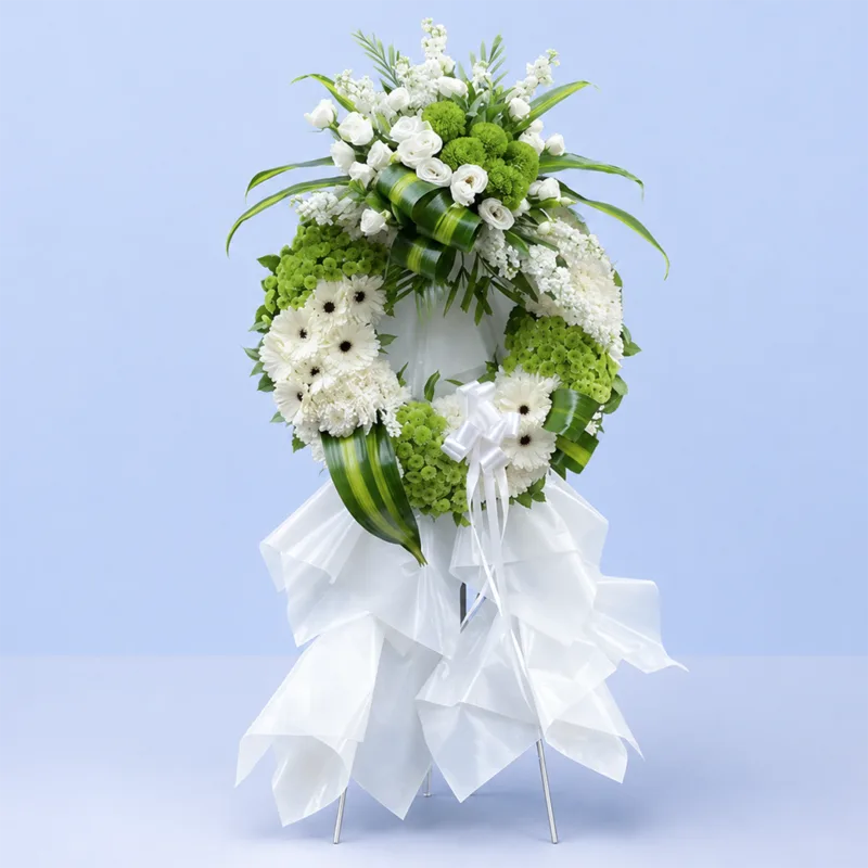 graceful-sympathy-flower-stand Graceful Sympathy Flower Stand featuring white gerberas, white and green chrysanthemums, white lisianthus, white matthiola, green trick, and fresh foliage arranged on a white steel sympathy flower stand.