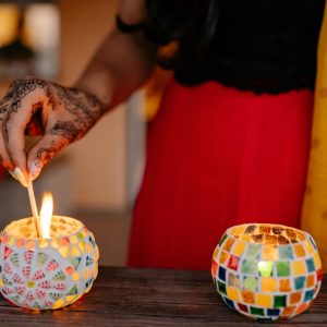 shows three small, round candle jars made of colorful mosaic tiles